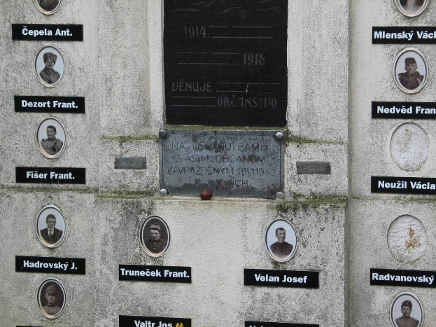 Ein Gedenkschild an einer Wand mit Fotos von Individuen und Text, das diejenigen ehrt, die im Zweiten Weltkrieg ihr Leben verloren haben.