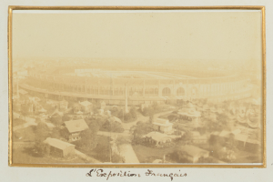 Altes Schwarz-Weiß-Foto eines Stadions inmitten einer städtischen Umgebung, umgeben von Gebäuden, Bäumen und Strommasten, mit Text unten.