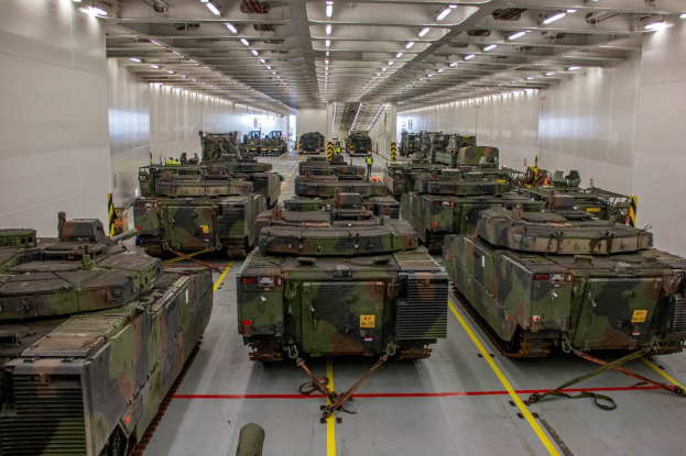 Ein grosser Militaraustellungsraum mit Reihen von Militaraerzten unter Deckenleuchten.