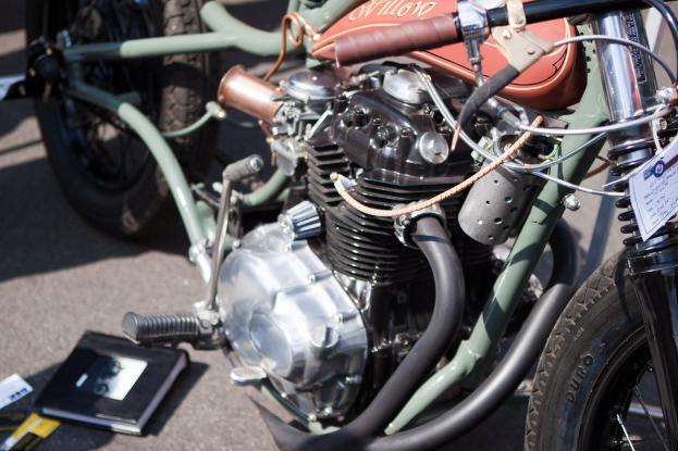 Mehrere Motorräder auf einem Parkplatz mit einem Buch auf einem der Sitze.