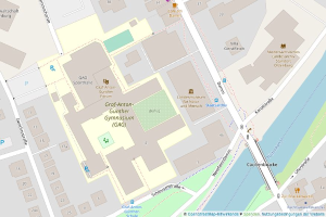 Eine detaillierte Stadtkarte mit Straßen, Gebäuden und Sehenswürdigkeiten, die einen rot umrandeten Parkplatz in der Mitte zeigt.