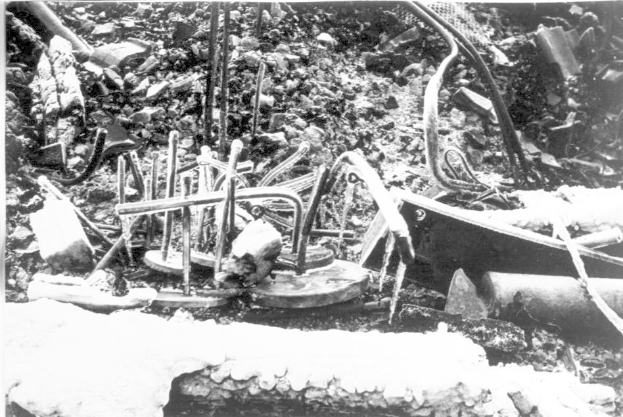 Ein Schwarz-Weiß-Foto eines Schutthaufens, einschließlich Metallgegenständen und Rohren, wahrscheinlich Überreste der Tschernobyl-Katastrophe.