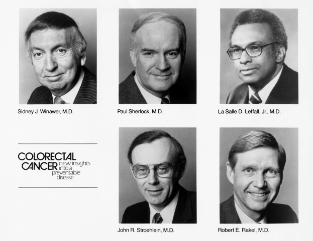 Schwarzes und weißes Foto von sechs Männern in Anzügen und Krawatten, jeder trägt eine Brille, posierend für die Kamera mit dem Text "Darmkrebs: Neue Einblicke in eine verhinderbare Krankheit" darunter.