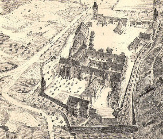 Luftaufnahme in Schwarz-Weiß einer Stadt mit einer zentralen Kirche, umgeben von Gebäuden, Bäumen und Straßen, mit Text am unteren Rand.