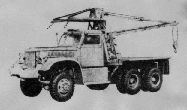 Schwarz-weiß-Foto eines großen Vierrad-Lkw mit einem Kran auf dem Rücken und einem flachen Anhänger, der angeblich das erste Schwerlastfahrzeug der Welt ist.