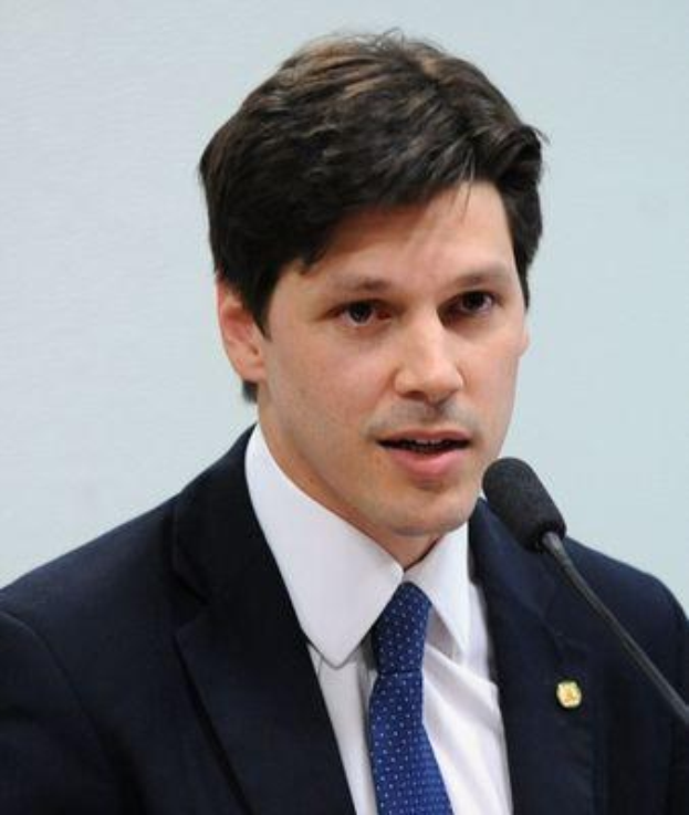 Ein Mann im Anzug spricht in ein Mikrofon und scheint die Genehmigung des Gesetzes durch die Regierung zu kommentieren.