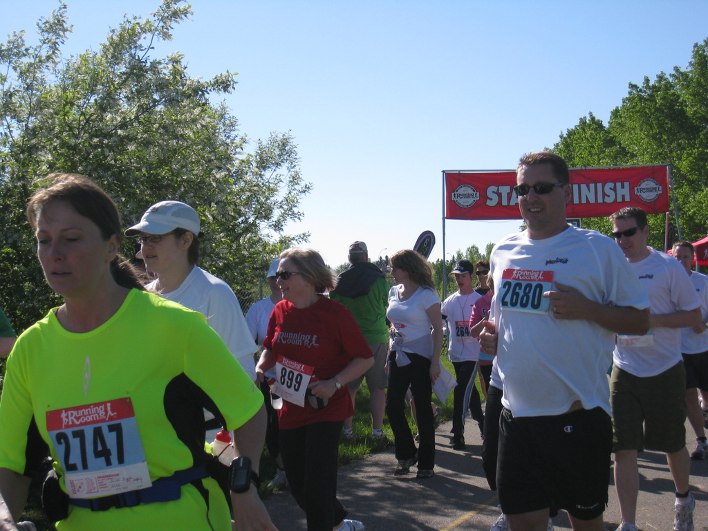 Eine Gruppe von Kindern beim Laufen in einem Marathon-Rennen, mit einem roten Banner und Bäumen im Hintergrund.