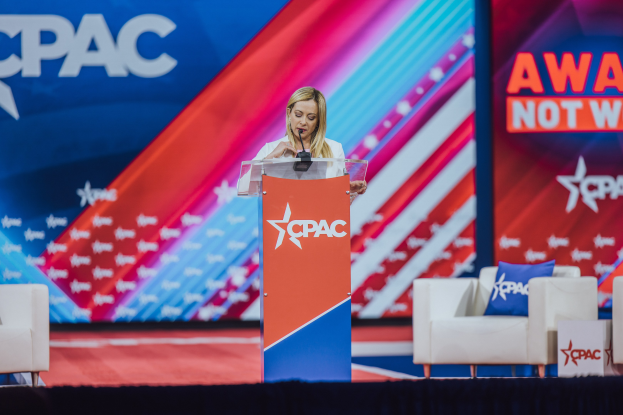 Frau am Rednerpult mit Mikrofon, flankiert von Stühlen mit Kissen, vor einem Bildschirm und einer Banner mit der Aufschrift "CPAC Awards 2019."