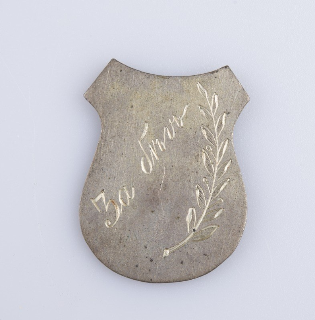 Silbernes Abzeichen mit Lorbeerkranz-Design, beschriftet mit "50. Geburtstag", auf weißem Hintergrund.